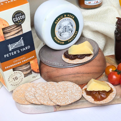 Luxury Cheese Gift Box displayed on a wooden table with cheeses, crackers, and chutneys, creating a perfect gourmet experience.