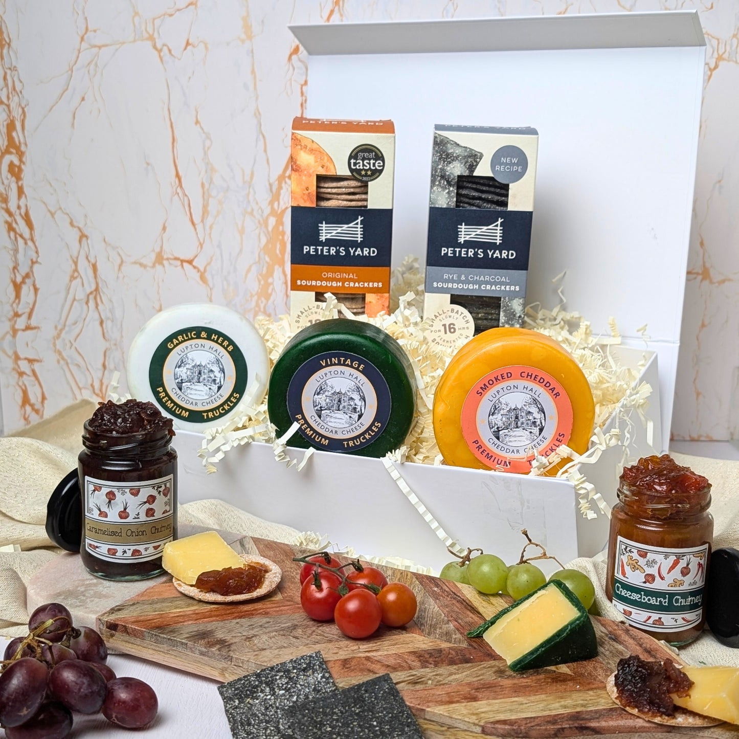 Complete selection of the Luxury Cheese Gift Box contents, including three artisan cheese truckles, chutneys, and sourdough crackers