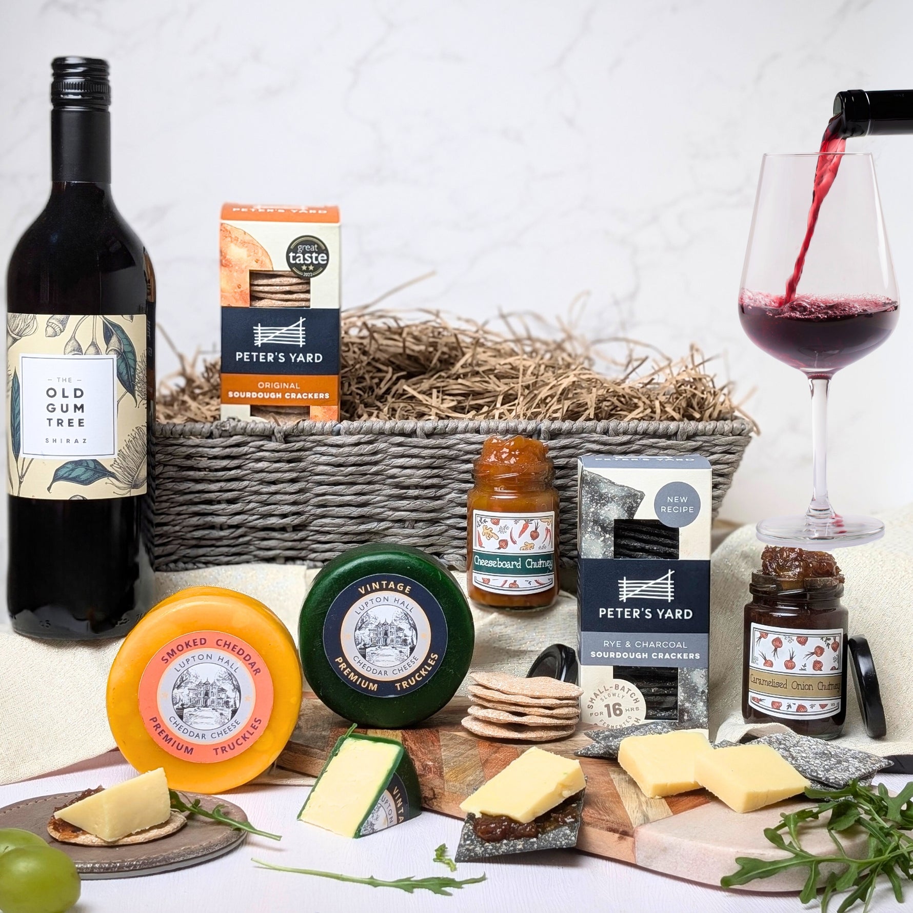 Cheese and Wine Gift Hamper Basket Set featuring artisan cheeses, chutneys, crackers, and a bottle of Old Gum Tree Shiraz, elegantly packed in a classic gift hamper basket—ideal for any occasion.